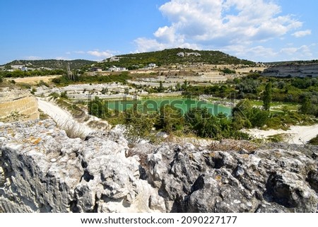 There is an artificial green lake inside the stone quarry. Inkerman. Crimea. August 2021
