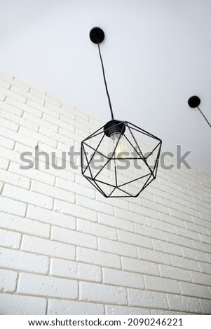 Ceiling lighting, lamp with light bulb in a geometric frame.