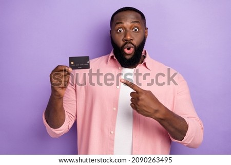 Photo of hooray millennial beard man indicate card wear pink shirt isolated on violet color background