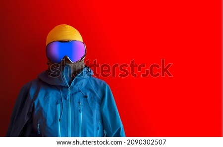 Snowboarder in full outerwear isolated over a red background.  Royalty-Free Stock Photo #2090302507