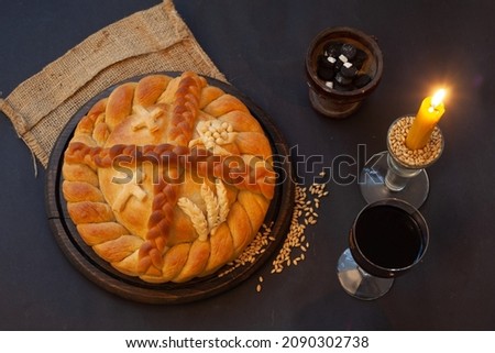 Serbian slava cake with wine and candle.  Slavski kolač. Decorative bread for traditional celebration. Royalty-Free Stock Photo #2090302738