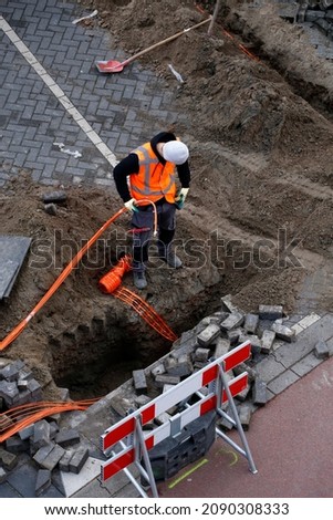 Installation  connecting of fibre optic cables by constructions workers to neighbouring houses Royalty-Free Stock Photo #2090308333