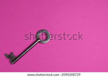 Key on a pink background, top view. Trendy colorful photo. Trendy minimal flat lay concept. Copy space.