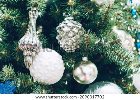 White and silver christmas balls on a christmas tree close-up
