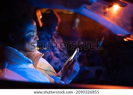Gadget addicted couple sit in car on parking in silence using smartphones and surfing social media. African american man and woman busy with mobile phones while spending time together. Selective focus Royalty-Free Stock Photo #2090326855
