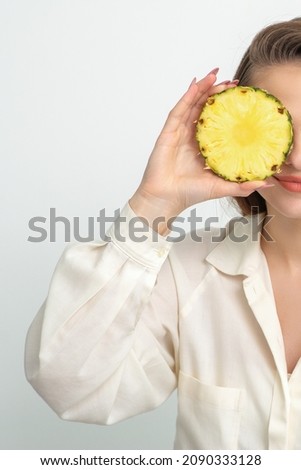 Attractive pretty nice young caucasian woman hold sliced pineapple covering her eye isolated on white color background