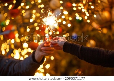 Two hands with sparklers on a Christmas or New Year's eve background
