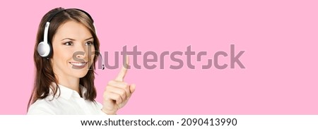 Call center service. Customer support female phone sales operator in white confident cloth headset show point click at copy space, imaginary or slogan text on rose pink color background. hot line help