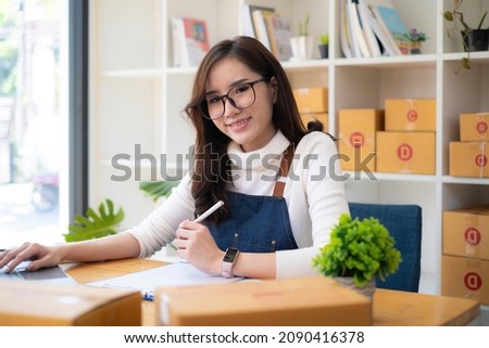 Small business owner with parcel box and working at her home to packing order before send to customer. Freelance working and SME entrepreneur concept.