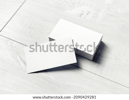 Blank business cards on light wooden background. Mockup for branding identity. Template for graphic designers portfolios.
