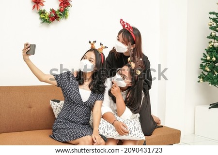 Due to the pandemic some people celebrate Christmas at home. These three Asian women are seen taking a picture together. Stay safe, stay healthy, and Merry Xmas!                              