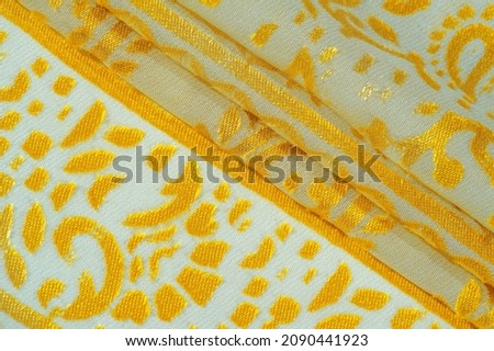 Silk fabric, golden pastels of delicate exquisite colors on a white background, Printed golden paisley photograph. Texture, pattern, collection