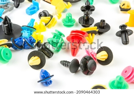 Close-up shot of plastic colored clips for the car.Abstract background. Panel plastic rivets isolated on white background. Auto plastic clasps. Insulated clip or automatic plastic clasp