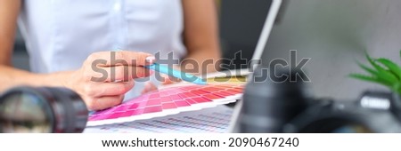 Woman designer holds color palette at desk. Selection of colors and shades in interior concept