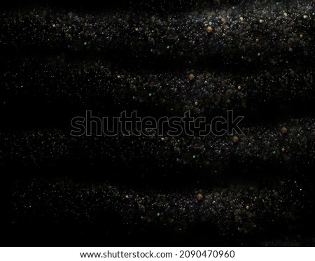 colorful glittering star magic dust on black background. Particles on dark backdrop. colourful glitter star dust blowing