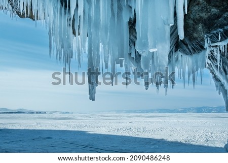 Inside the ice cave with icicles on the Lake Baikal in winter. Siberia, Russia. Royalty-Free Stock Photo #2090486248