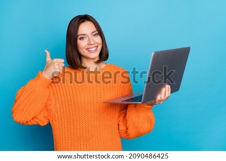Portrait of pretty trendy cheerful skilled girl using laptop showing thumbup isolated over bright blue color background