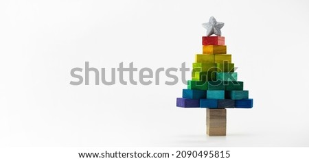 Christmas tree made from colorful wooden blocks. Christmas in colorful spectrum of colors. Isolated on neutral white with natural shadows.
