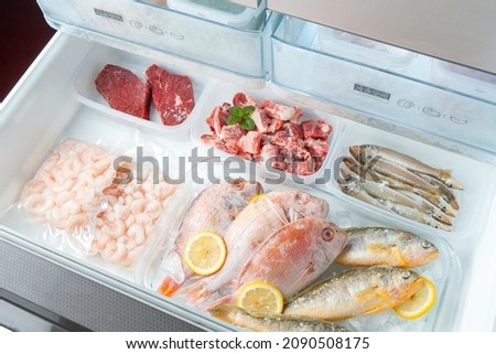 different frozen meat on the opening freezer shelves. food storage. Royalty-Free Stock Photo #2090508175