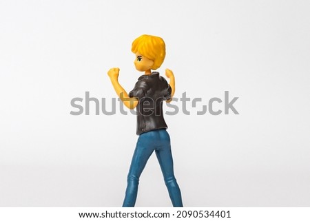 Miniature toy woman girl dancing. little young woman dancing on a gray white background,copy space.