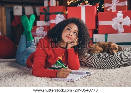 Full size photo of young african woman happy positive smile dream think write notes idea animal new year indoors