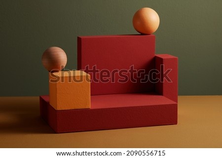 Red and orange podium with wooden sphere in a grey background for abstract advertising , front view  Royalty-Free Stock Photo #2090556715