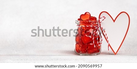 Heart shaped mockup greeting card and a jar full of hearts. Love. St Valentines Day card. 14 February, wedding invitation or thank you concept. Greeting card with copy space