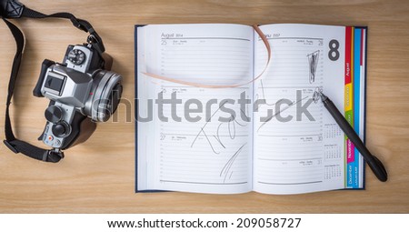 Note Book on Wooden Table  with word " Travel "