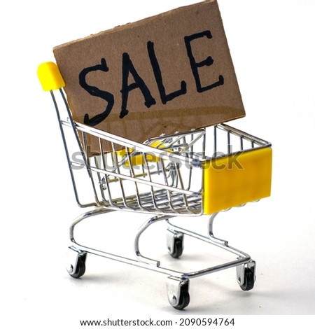 shopping basket with a cardboard sign with the inscription sale. High quality photo