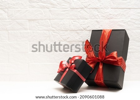 gift with a red ribbon. Black gift box