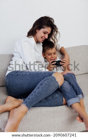 mother and son playing gadget smartphone on the couch
