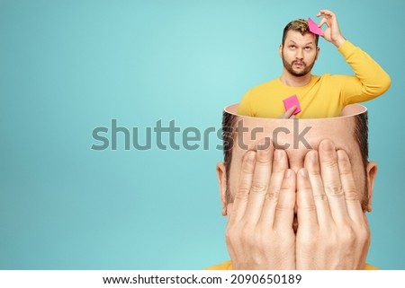 In the man's open head, the brain glues stickers to itself. The concept of memory work, memorization process, brain work. copy space Royalty-Free Stock Photo #2090650189