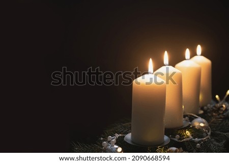 Fourth advent, four candles - candlelight on dark brown panorama background - advent banner. Horizontal banner for homepage. Template for greeting cards, funeral cards and obituaries.