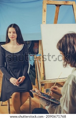 young artist paints a portrait of a beautiful girl