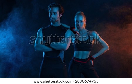 Sprinter run. Strong athletic woman and man running on black background wearing in the sportswear. Fitness and sport motivation. Runner concept. Royalty-Free Stock Photo #2090674765