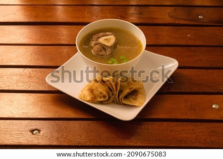 This image shows a serving of bone marrow soup and chapati.