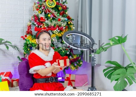 woman wearing christmas outfit holding gift video call