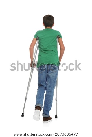 Teenage boy with injured leg using crutches on white background, back view Royalty-Free Stock Photo #2090686477
