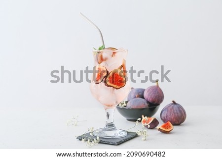 Composition with tasty fig lemonade on light background