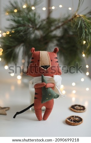 cute soft toy tiger with decorations on a cozy Christmas or New Year background. symbol of 2022, oriental calendar concept