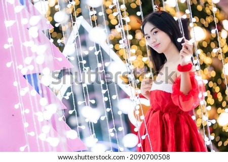 happy portrait young asian woman Santa costume and Christmas greeting picture parcel decoration on Christmas tree light Abstract circular bokeh background Decoration During Christmas and New Year.