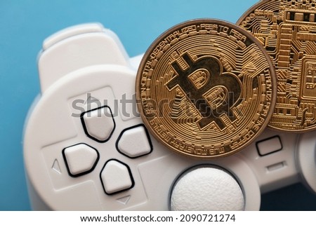 Crypto gaming concept. Video game controller with a bitcoin cryptocurrency coin Royalty-Free Stock Photo #2090721274