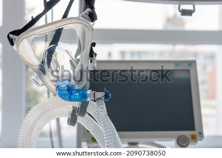 Non-invasive ventilation face mask, on background medical ventilator in ICU in hospital.  Royalty-Free Stock Photo #2090738050
