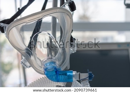 Non-invasive ventilation face mask, close up view, on background medical ventilator in ICU in hospital. Royalty-Free Stock Photo #2090739661