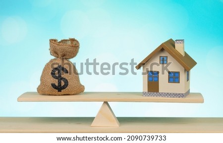 Home and money bag Us dollar sign put on the scales with balance saving for a real estate concept loan for plan business investment in the future