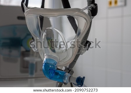 Non-invasive ventilation face mask, close up view, on background medical ventilator in ICU in hospital. Royalty-Free Stock Photo #2090752273
