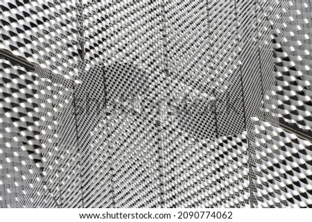 Double exposure of transparent glass and perforated metal surfaces resembling futuristic hi-tech architecture. Industrial and technological background with black and white geometric pattern.