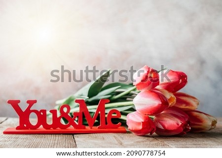 Red tulips bouquet with red you and me wooden sign Valentine's Day background