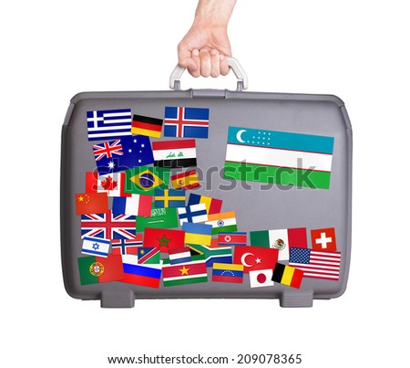 Used plastic suitcase with lots of small stickers, large sticker of Uzbekistan