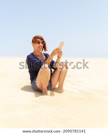 Girl taking a selfie in the golden sand